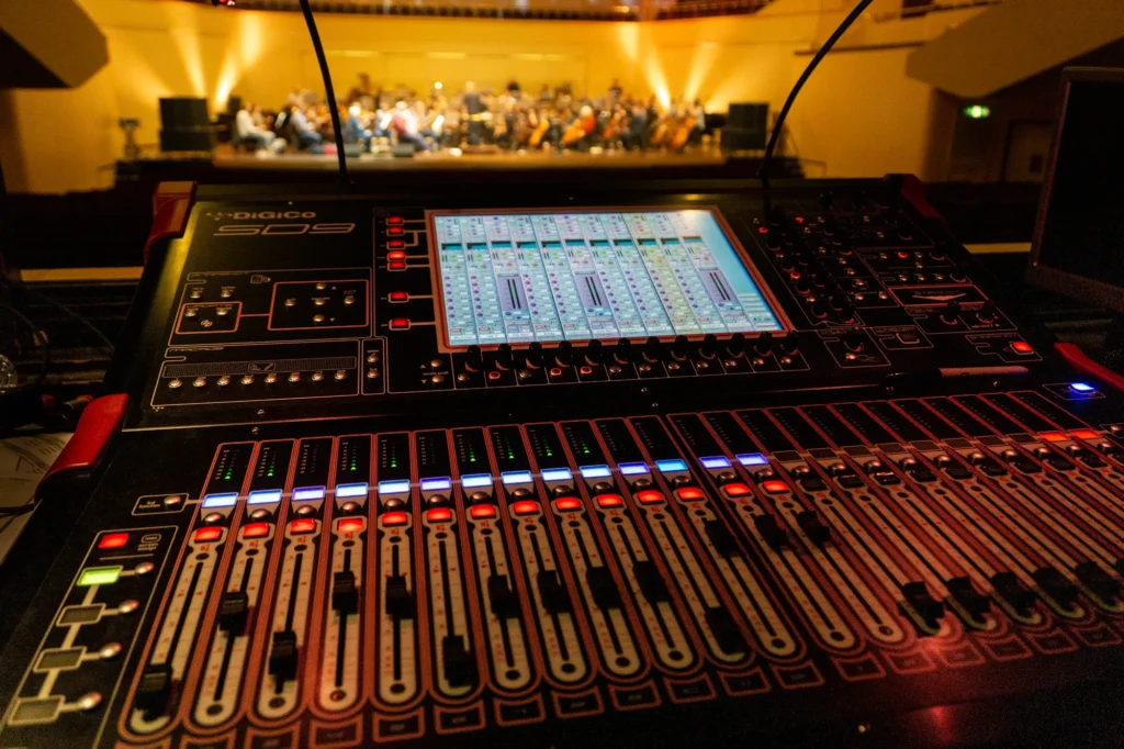 Orchestra rehearsals ahead of the New Year’s Eve Sinfonia Viva concert at the Royal Concert Hall in Nottingham. The orchestra are blurred in the distance of a shallow depth of field image with a DiGiCo SD9 mixing console in focus covering much of the photo area.