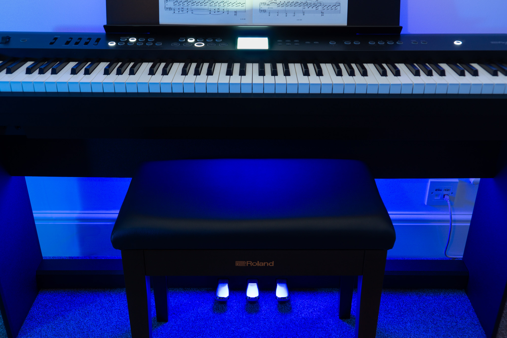 Staight on close up shot of a Roland FP-E50 digital piano in blue mood lighting in the Capybara Sound studio live room.