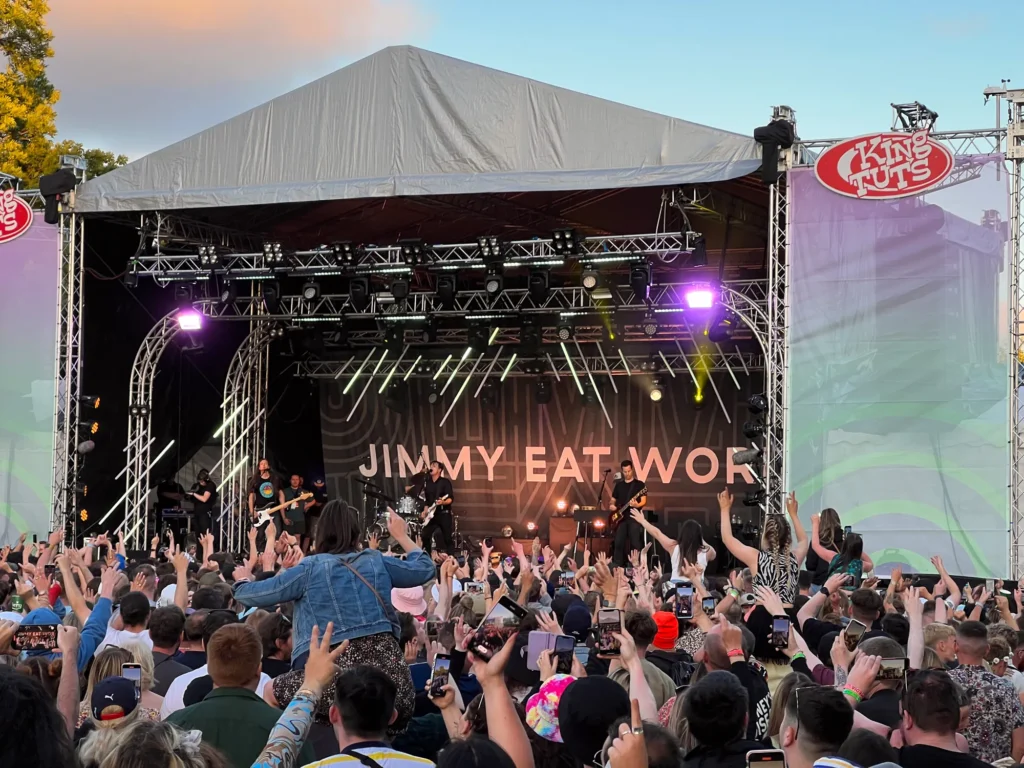 Jimmy Eat World performing on the King Tuts stage at Glasgow TRNSMT Festival to a large audience with some people sitting on other's shoulders to get a better view.