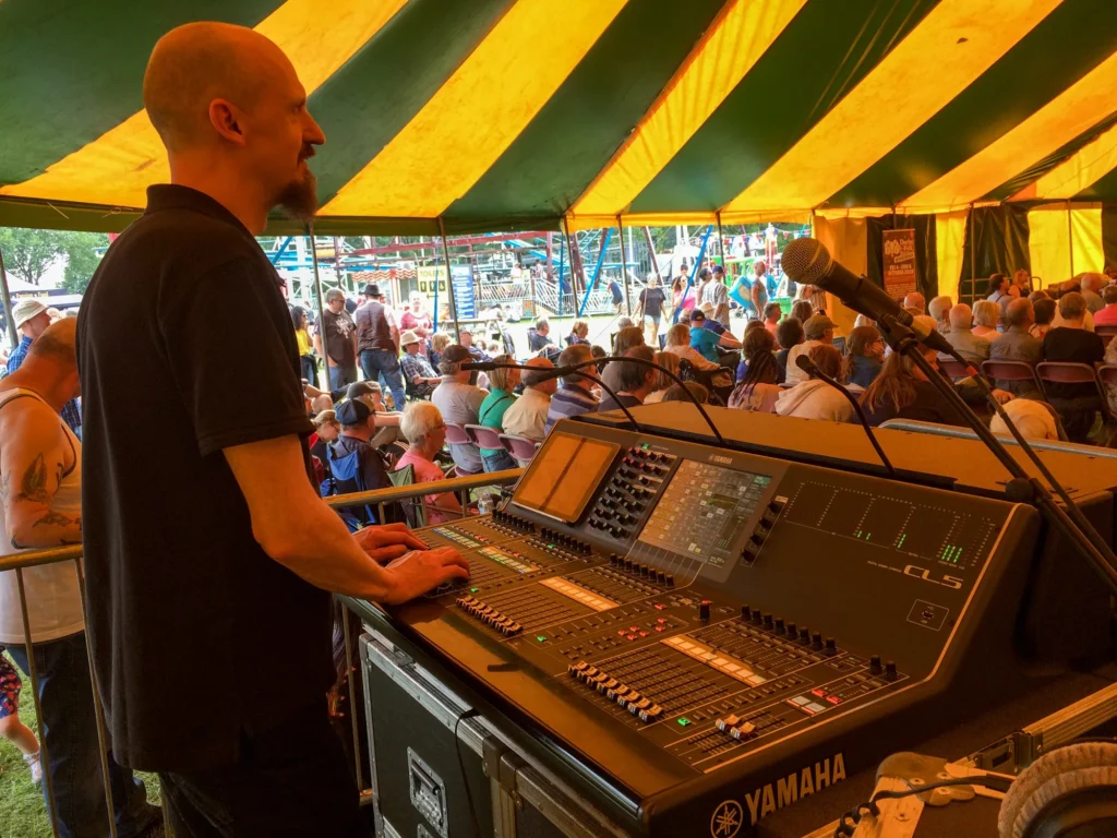 Sound engineer Jamie Rhodes-Simpson working front of house sound, operating a Yamaha CL5 digital mixing console at Nottingham Riverside festival.